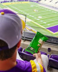 Football fan eating kudo snacks, a keto friendly high protein popcorn alternative to the others.
