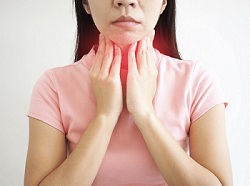 Lady holding her irritated throat in need of the best natural remedies for acid reflux