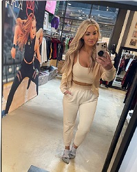 Beautiful blonde woman walking through women's activewear store advertising women's sport apparel