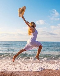Lady skipping happily on the beach representing how bran can improve mood and focus naturally