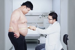 Obese guy standing in the doctors office trying to figure a solution for weight management from eating foods with additives and chemicals.